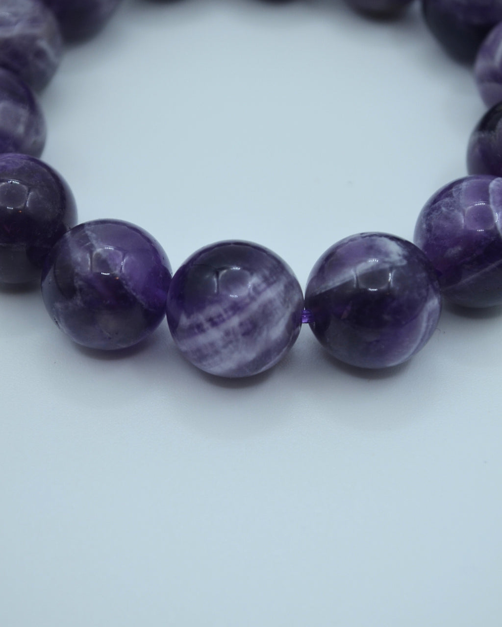 Close-up of a purple beaded bracelet on a white background