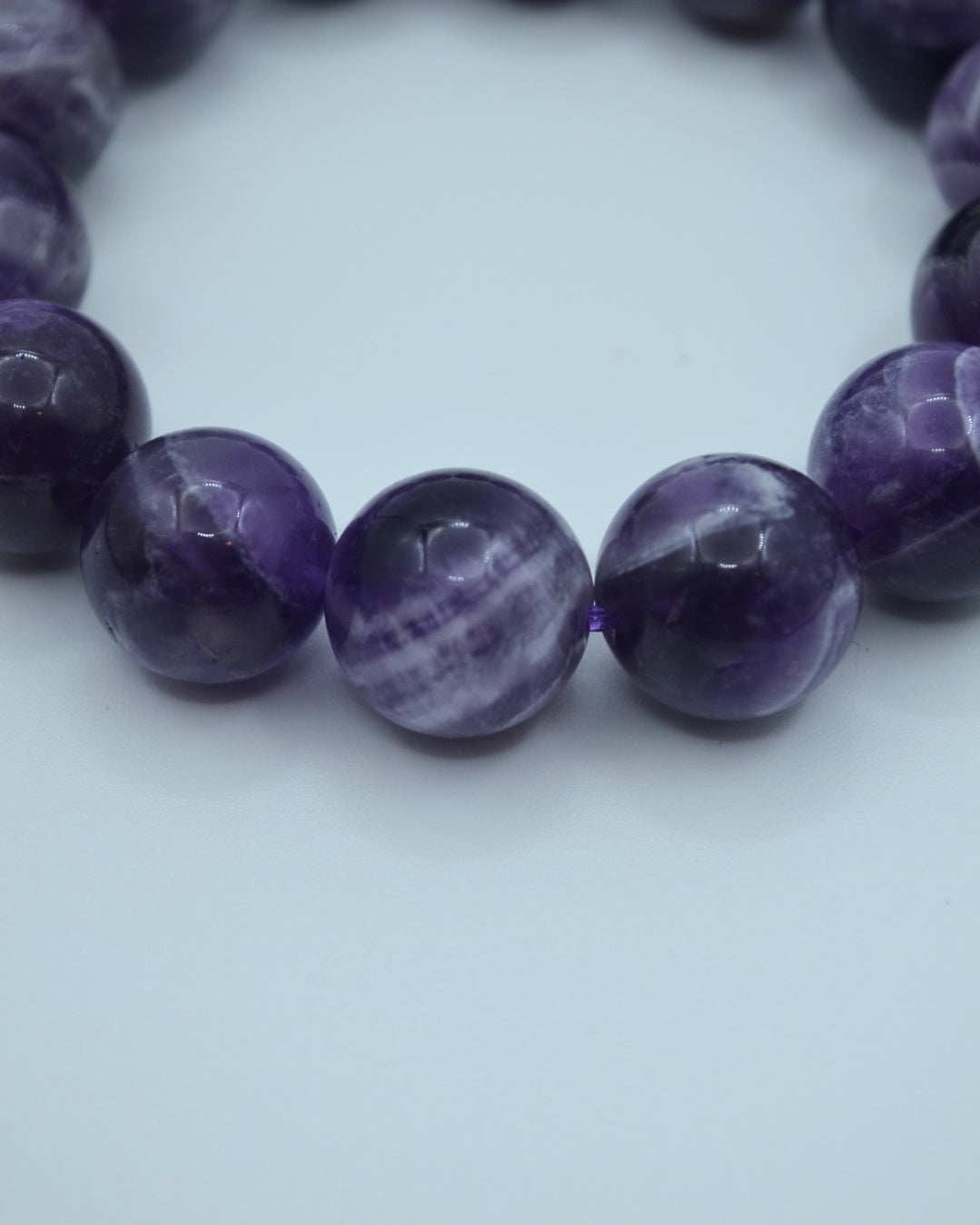 Close-up of a purple beaded bracelet on a white background