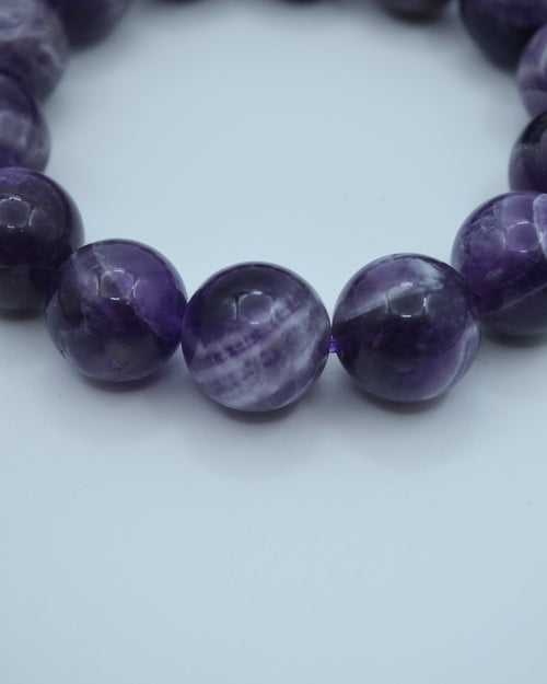 Close-up of a purple beaded bracelet on a white background