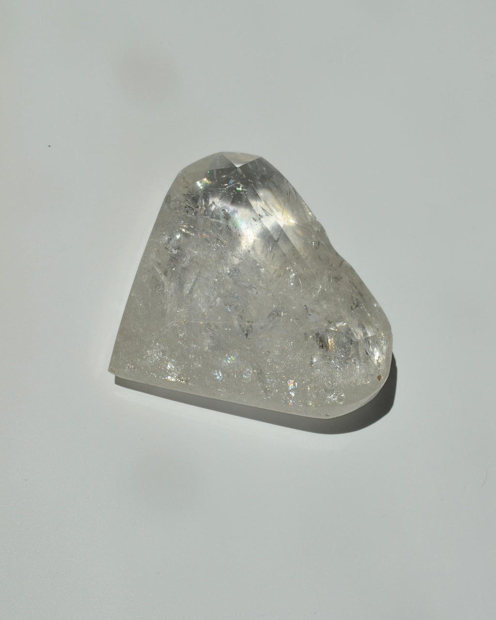clear quartz shaped in a heart on a light gray background