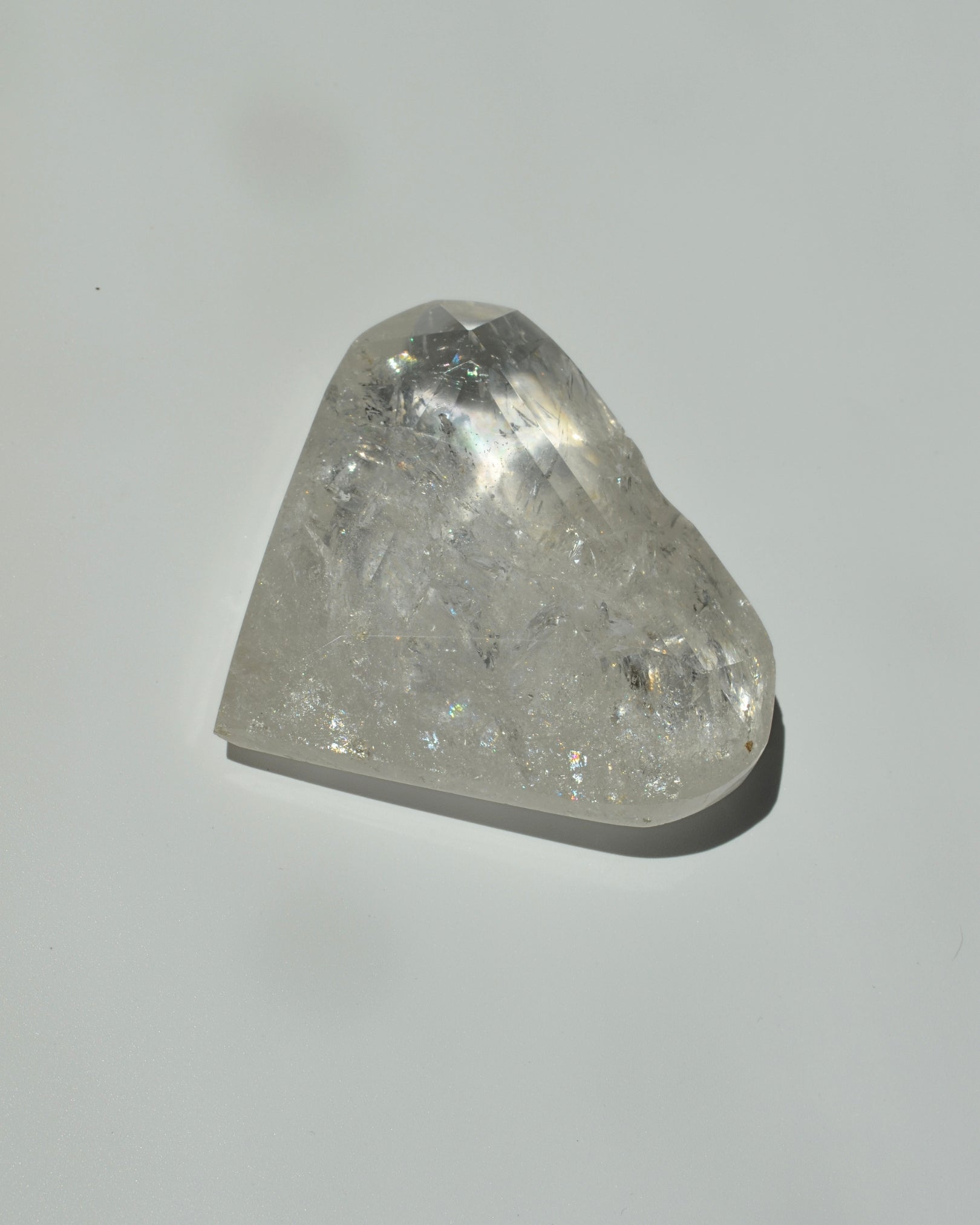 clear quartz shaped in a heart on a light gray background