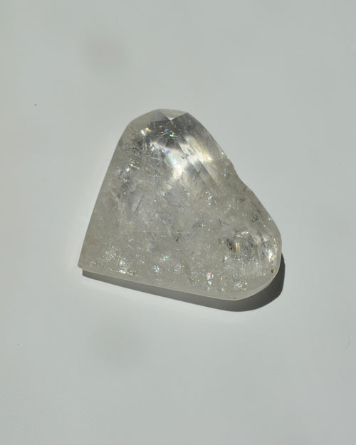 clear quartz shaped in a heart on a light gray background