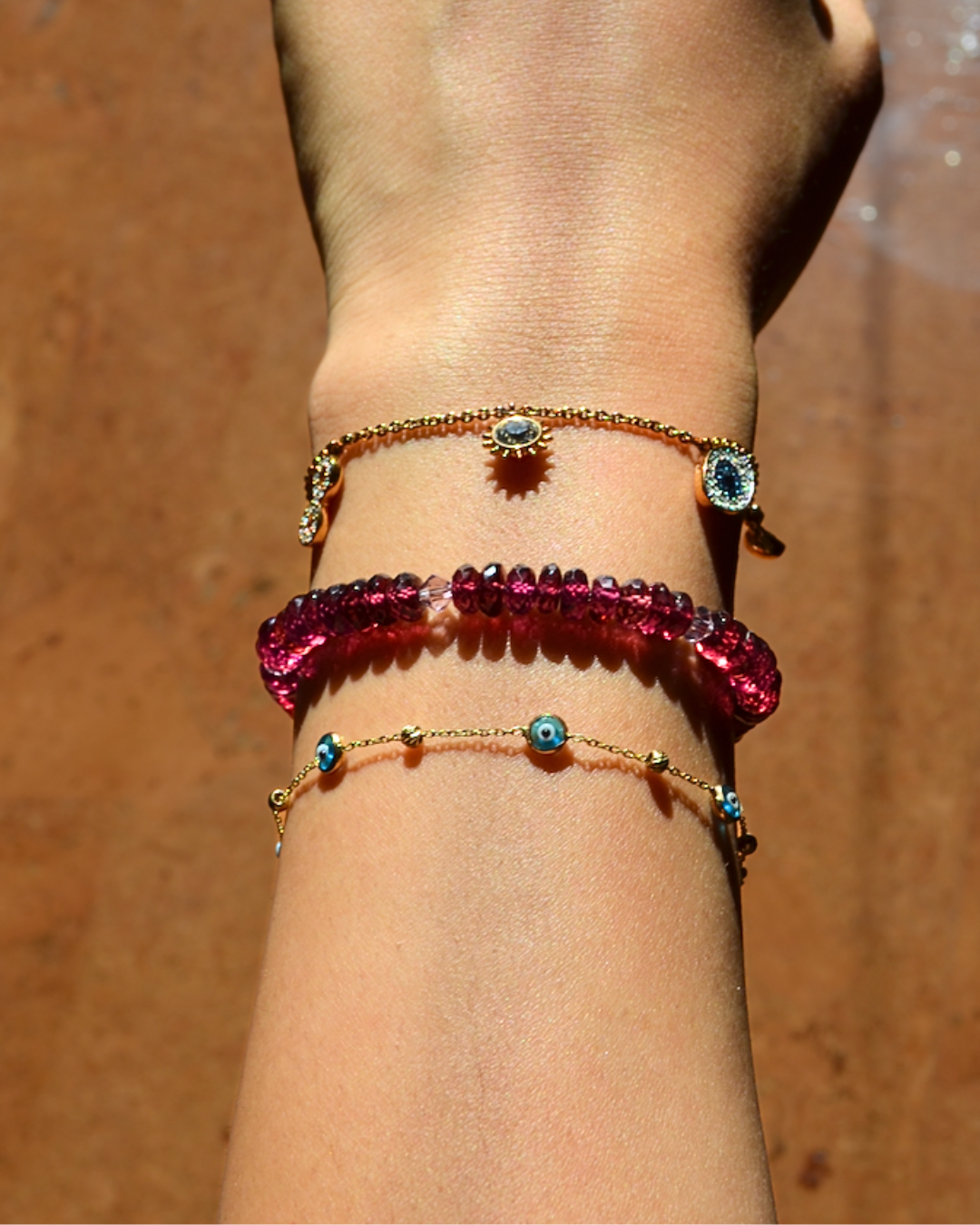 Close-up of a wrist wearing two beaded bracelets on a wooden surface