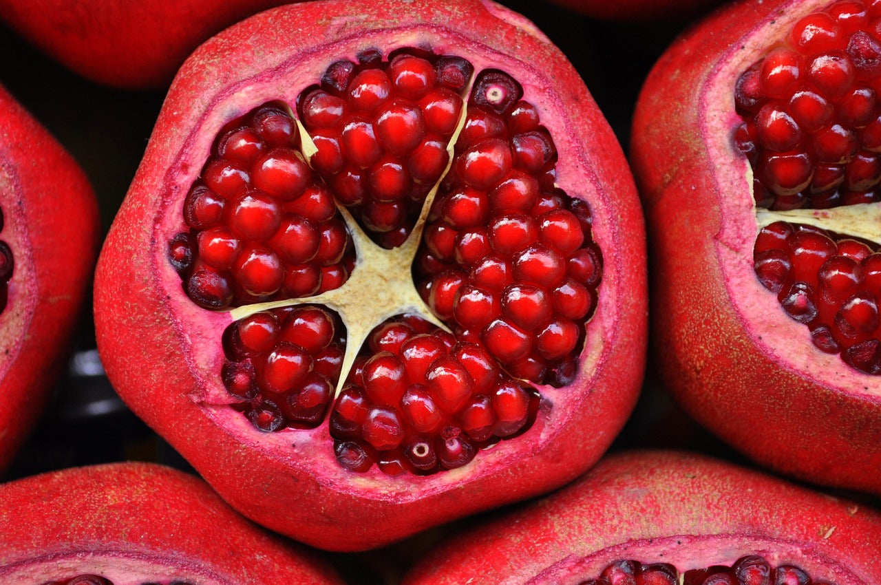 Close-up of a halved pomegranate with juicy red seeds.
