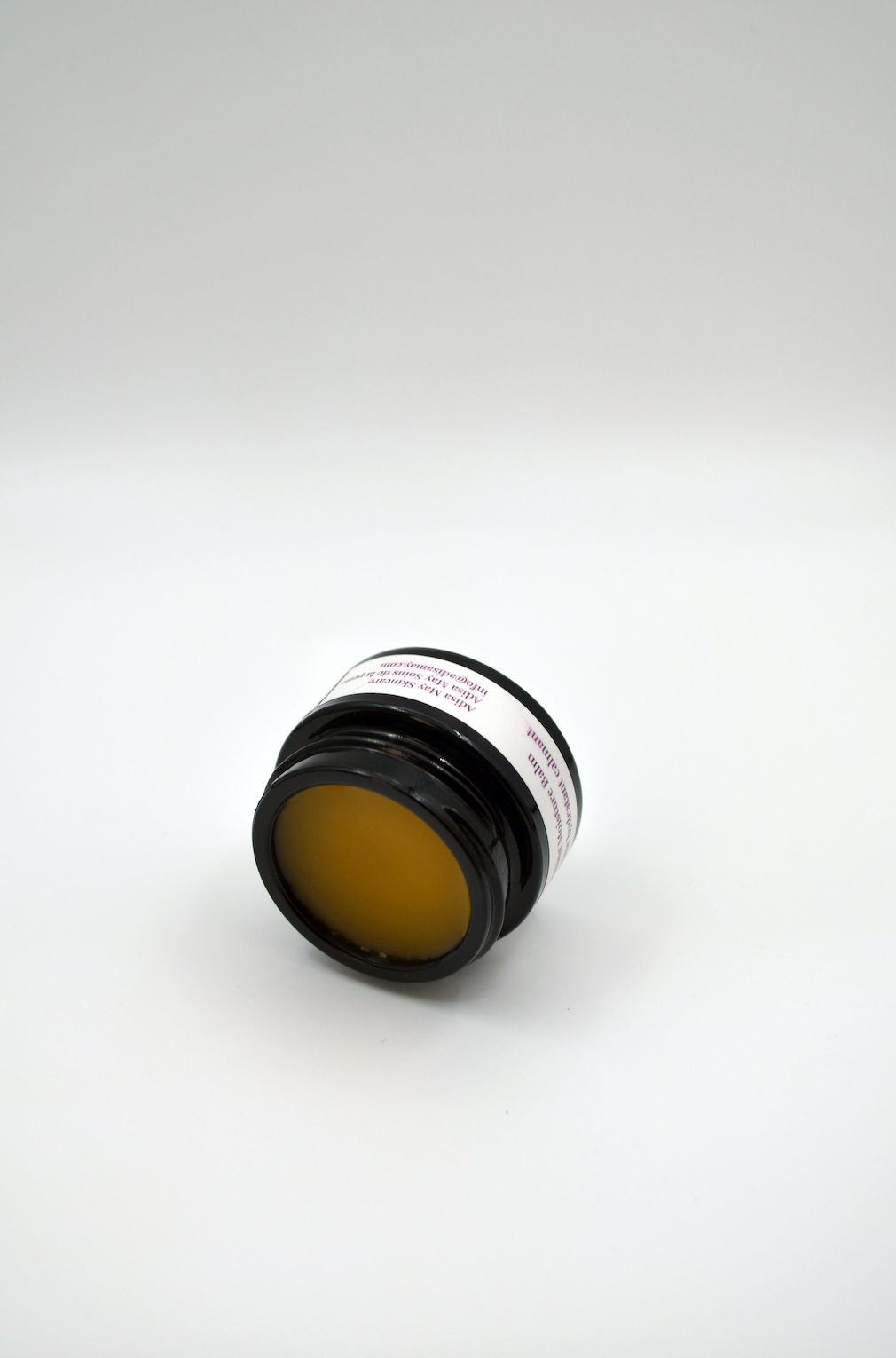Jar of orange cream with a white label on a white background