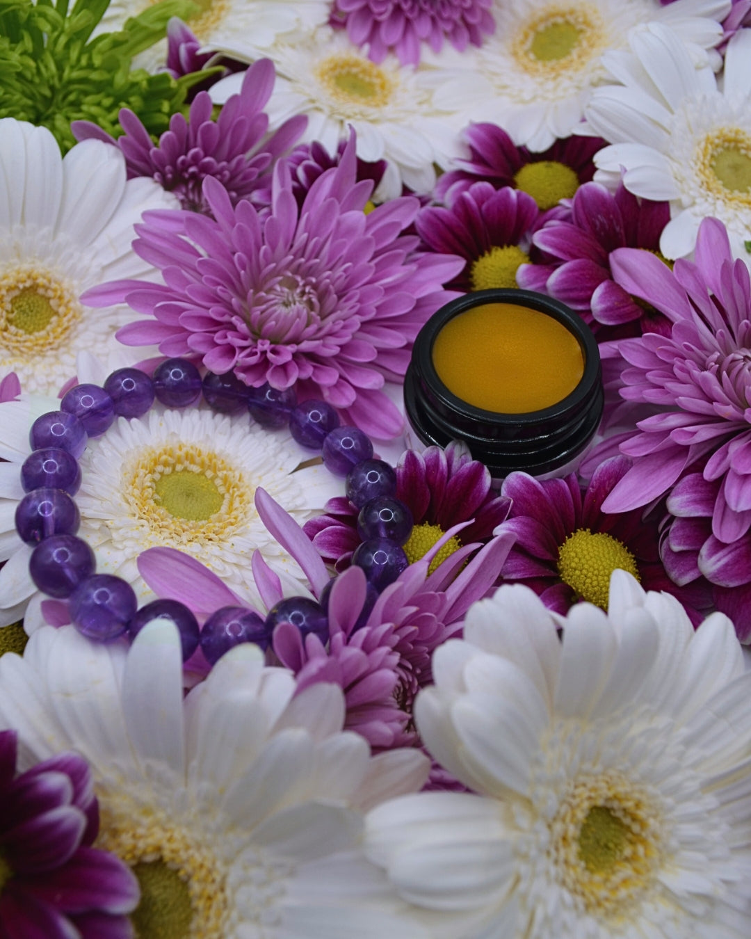 Floral arrangement with a small container of yellow substance in the center.